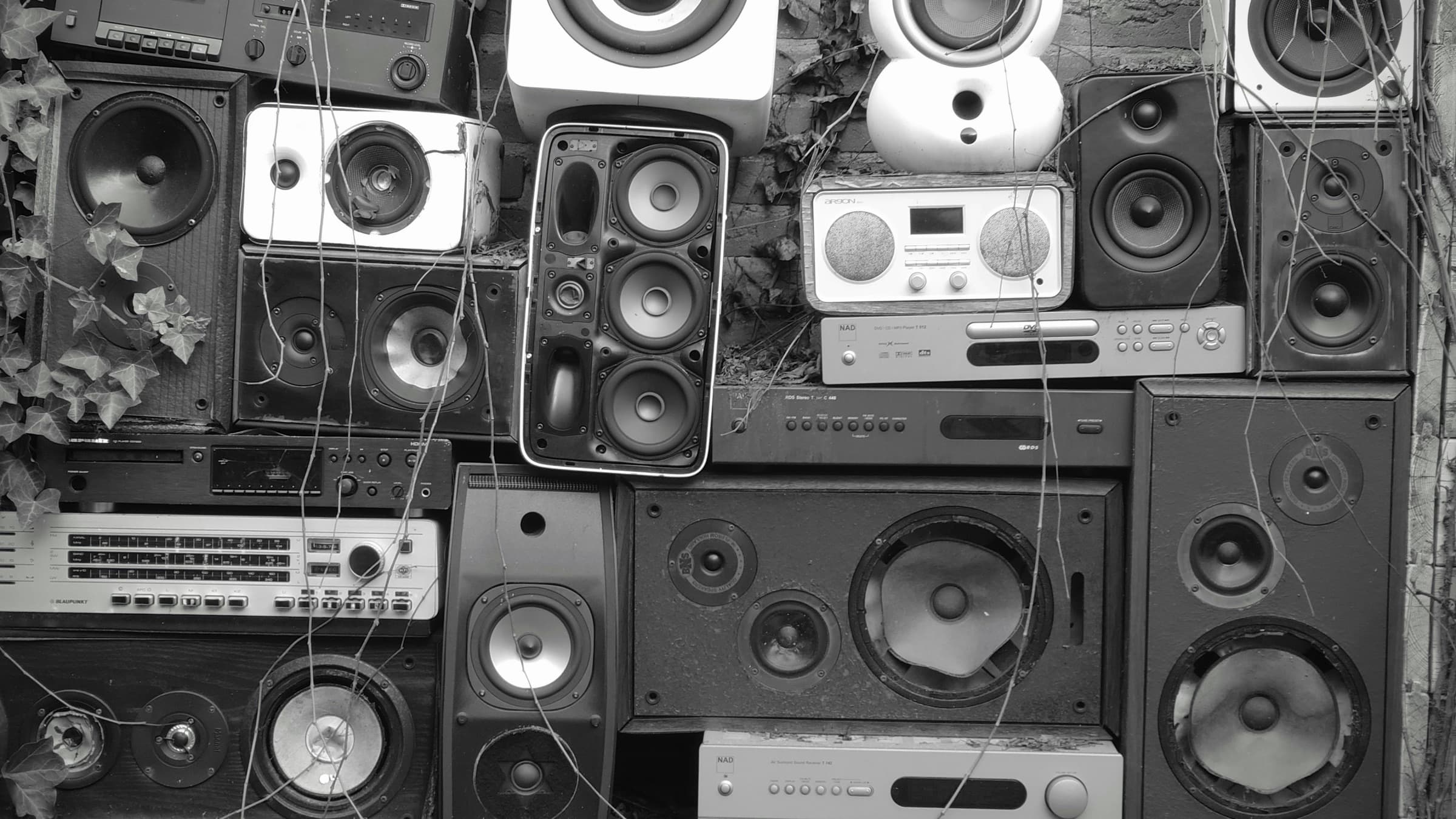 Black-and-white collection of loudspeakers and audio equipment, used as illustrative photography